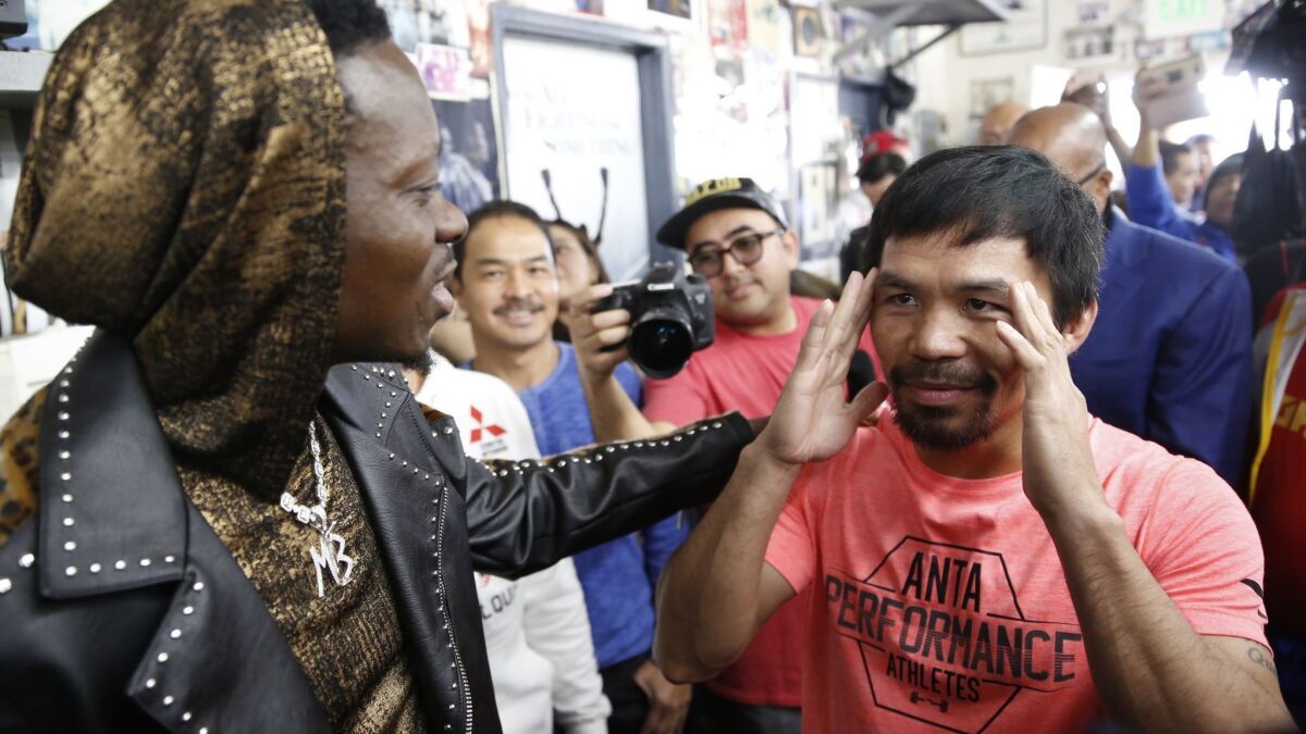 Manny Pacquiao, right, comments on his concentration before a fight, as he chats with comedian Michael Blackson, left, as he arrives at a boxing club in Los Angeles on Wednesday.