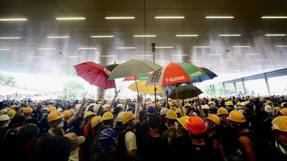 Protesters hold up umbrellas as they break into the Legislative Council building on July 1, 2019, during the annual pro-democracy march in Hong Kong.