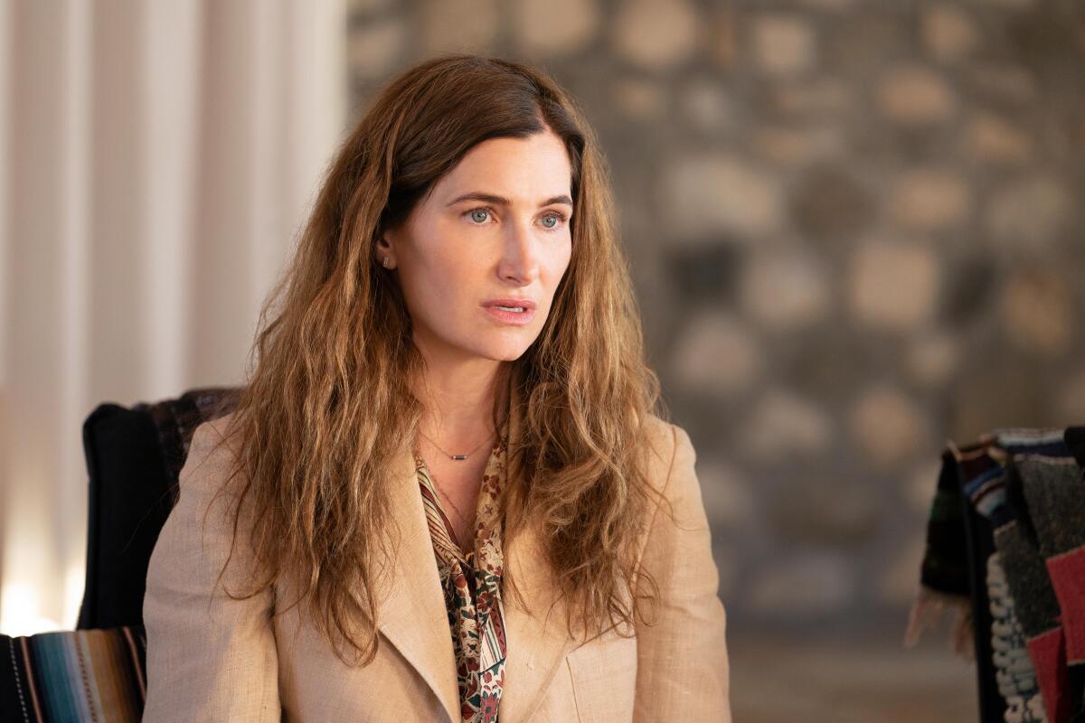 Kathryn Hahn sits in a chair and looks serious in "Tiny Beautiful Things."