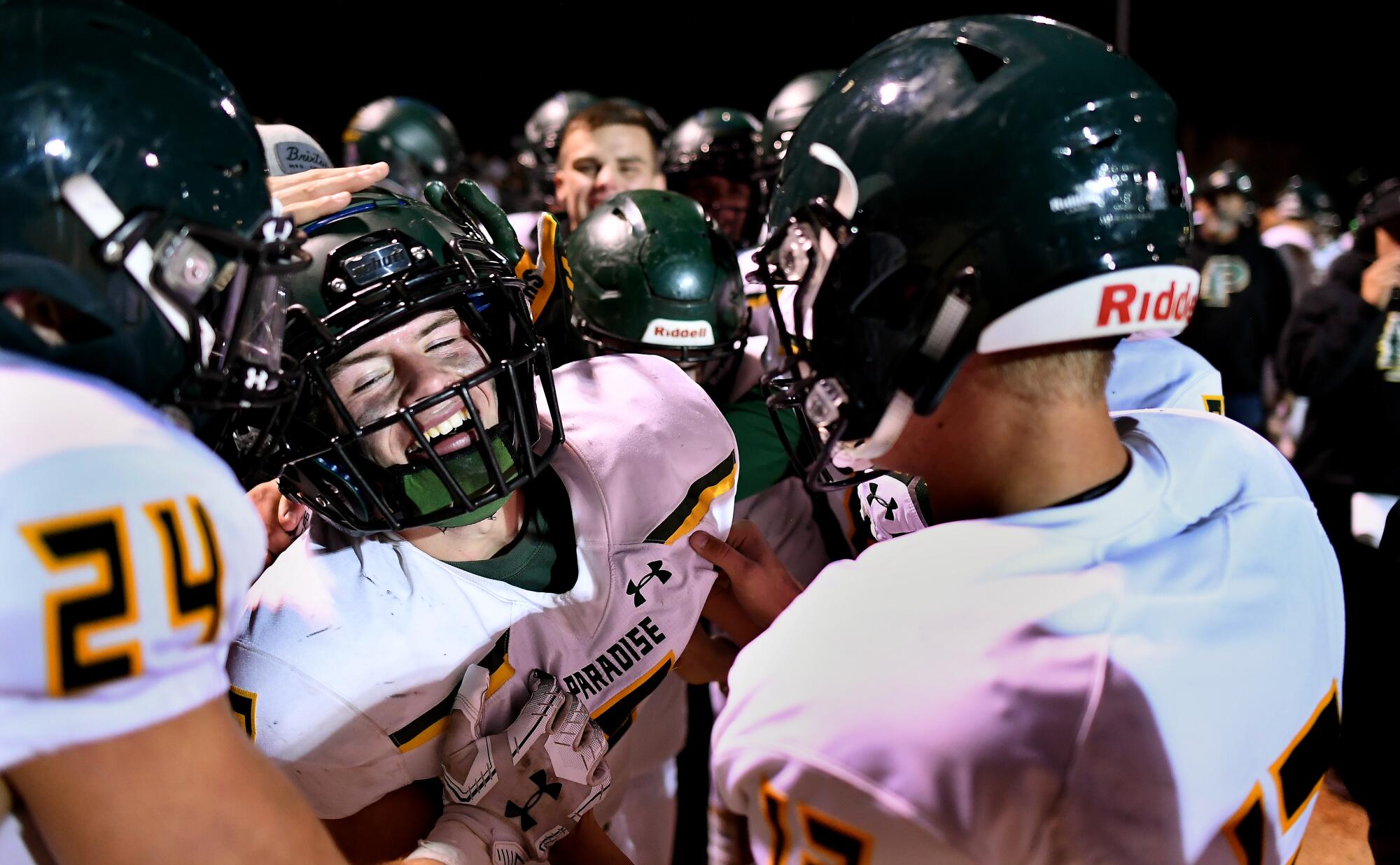 Paradise's Brenden Moon is congratulated by teammates after scoring a touchdown.