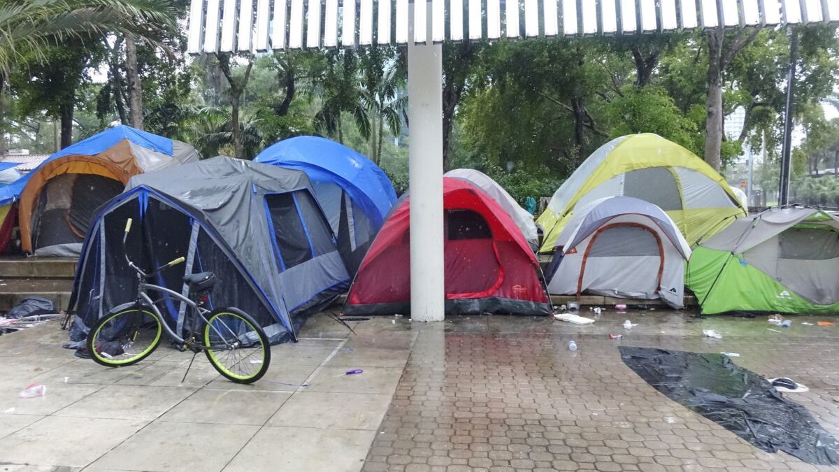 Rain pours down on a homeless encampment in Fort Lauderdale, Fla., on May 20, the day after a raid on another homeless camp that led to a lawsuit against the city.