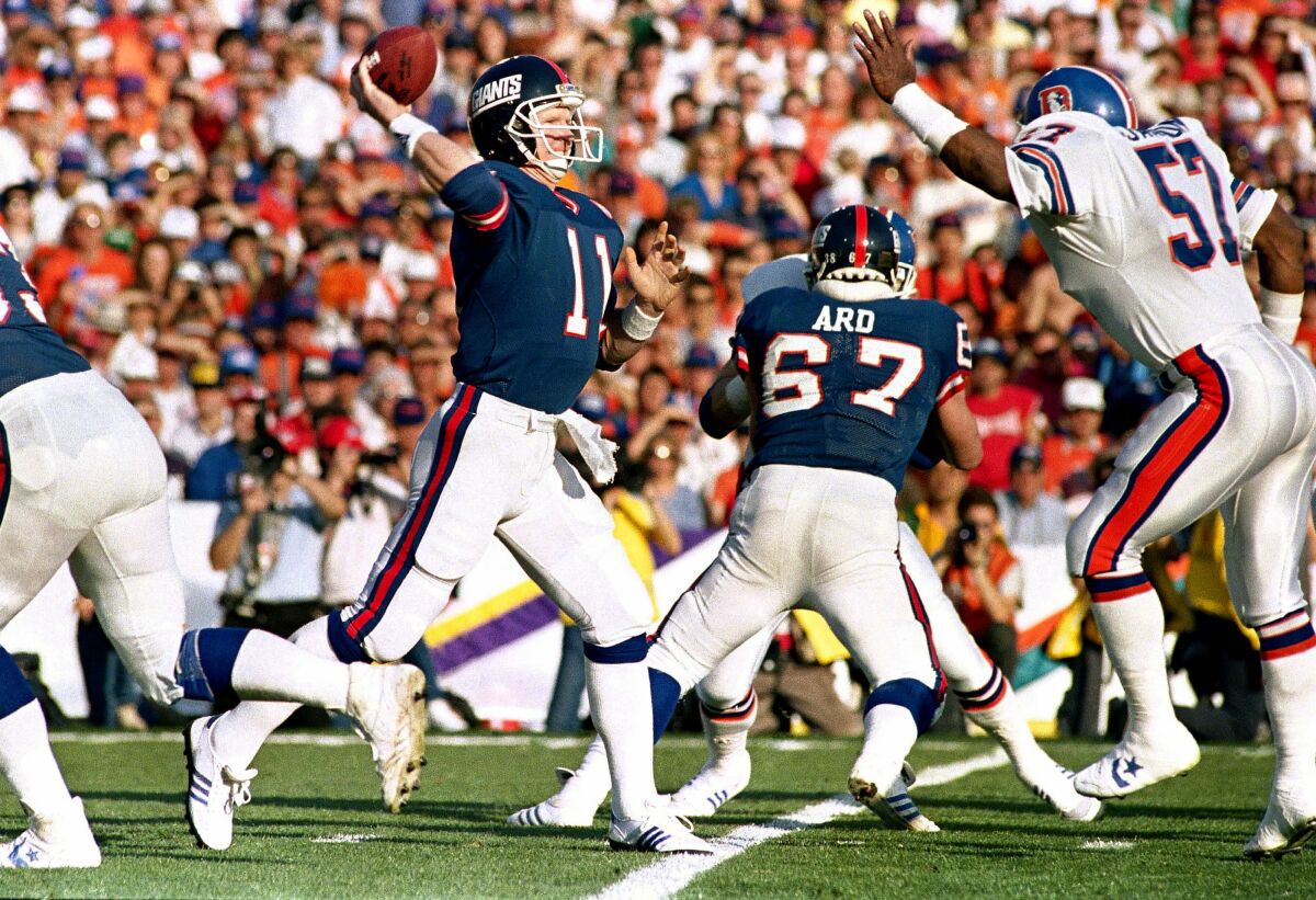 New York Giants quarterback Phil Simms (11) looks to throw the ball against the Denver Broncos