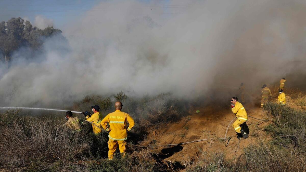 On July 31, 2018, firefighters near the Israeli city of Sderot extinguish a fire in a forest field that was caused by an incendiary balloon flown by Palestinian protesters.