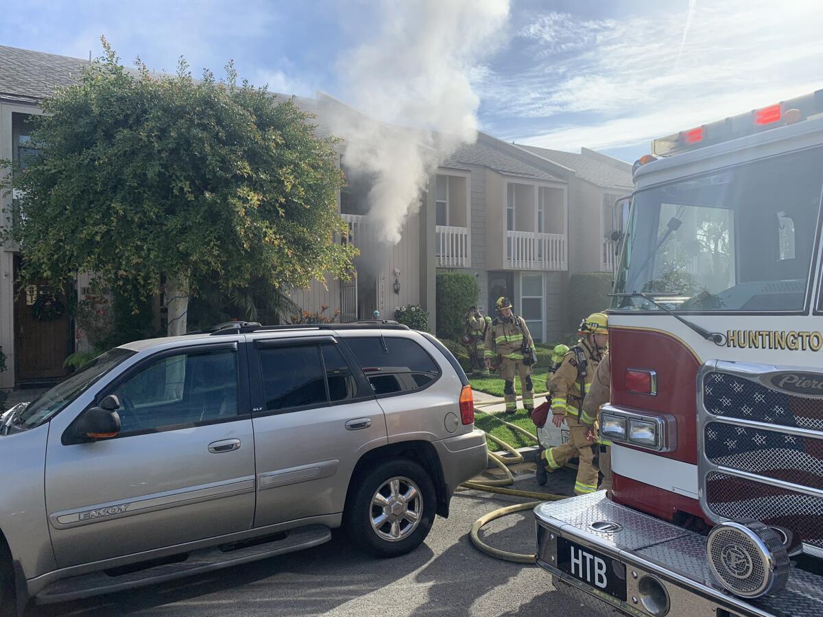 Huntington Beach firefighters respond to a townhouse blaze Friday morning in the Huntington Harbour community.