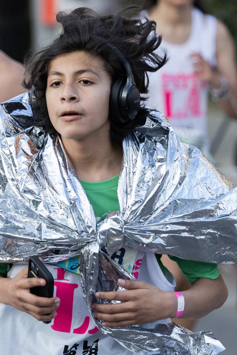 洛杉矶马拉松比赛中，一名跑步者裹着保暖毯。