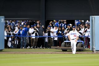 Dodgers starting pitcher Clayton Kershaw warms up as the crowd watches before a game April 18, 2023 in Los Angeles.