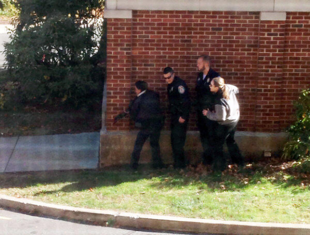 In this photo taken through a window and provided to the AP, which has been authenticated based on its contents and other AP reporting, police officers respond to a report of a suspicious person at Central Connecticut State University in New Britain, Conn.