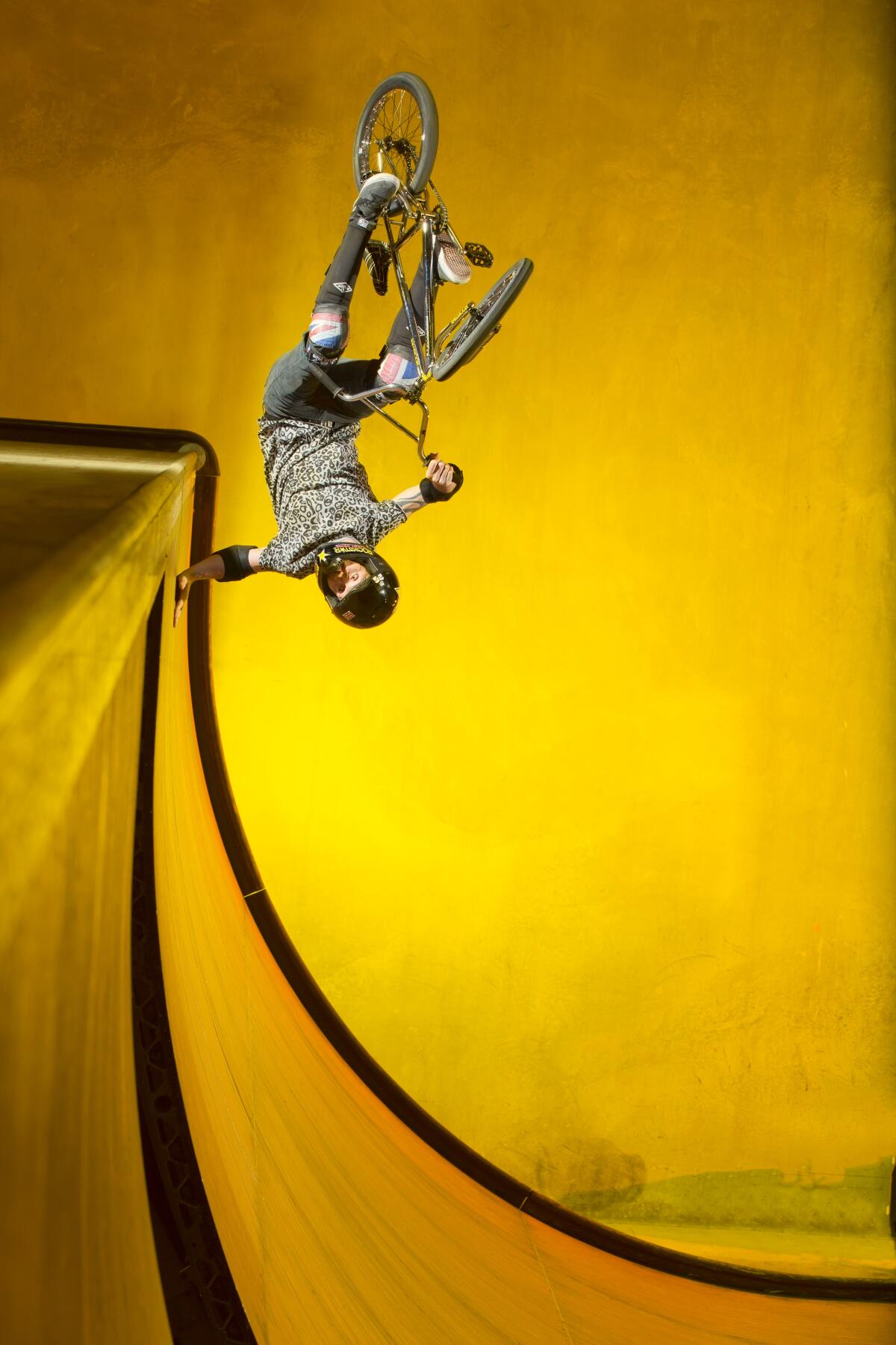 Eight-time BMX world champion Simon Tabron doing a trick on a vertical ramp.