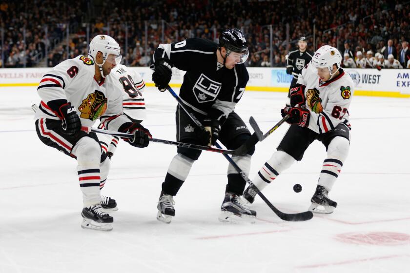 The Kings' Tanner Pearson splits the defense of Chicago's Trevor Daley, left, and Tanner Kero on Nov. 28.