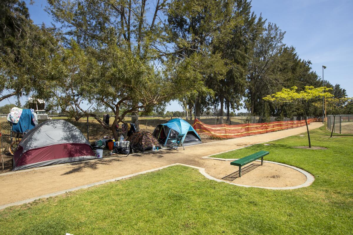 Three tents sta along a walking path near the Fountain Valley Sports Park at Mile Square Park on Thursday.
