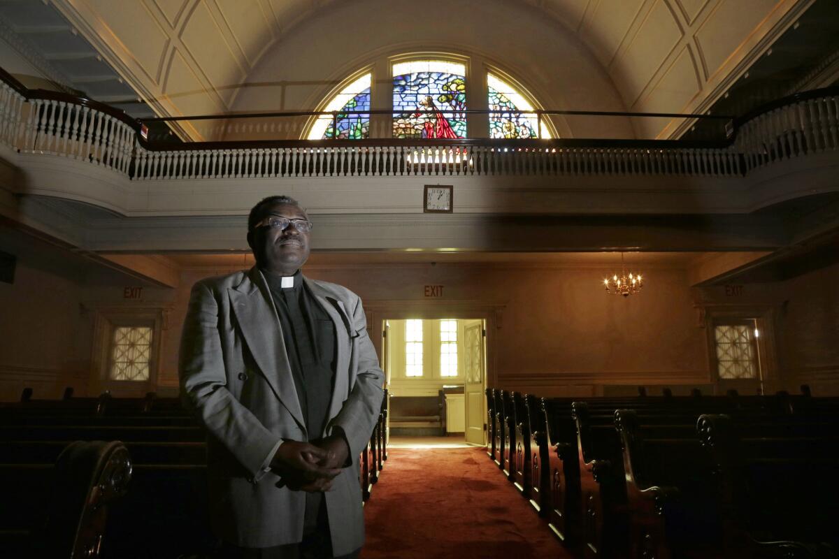In this Dec. 6, 2016 photo, Pastor Abraham Waya poses inside the Central United Methodist Church in Brockton, Mass., after announcing the church will become an immigrant sanctuary. Hundreds of houses of worship representing an array of faiths around the country are offering to provide sanctuary for people who could face deportation if President-elect Donald Trump follows through on his campaign pledge.