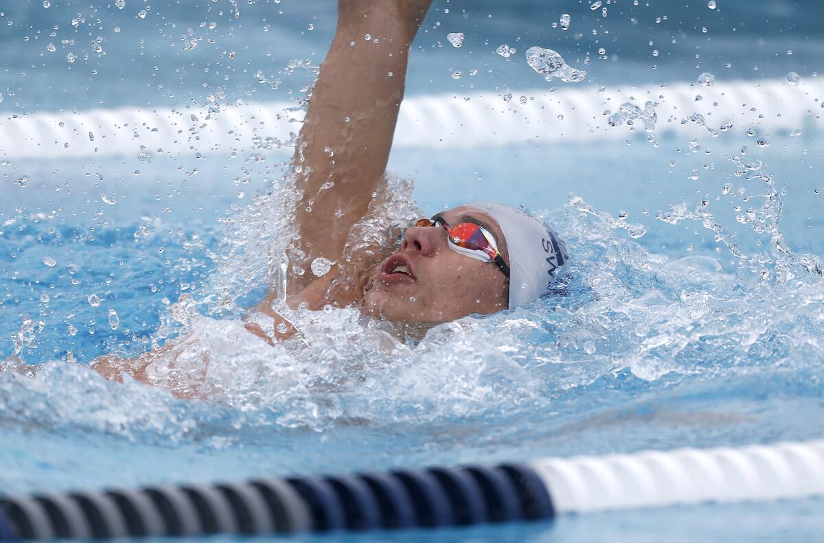 Newport Harbor's Aidan Arie swims the backstroke during the medley relay on Tuesday.