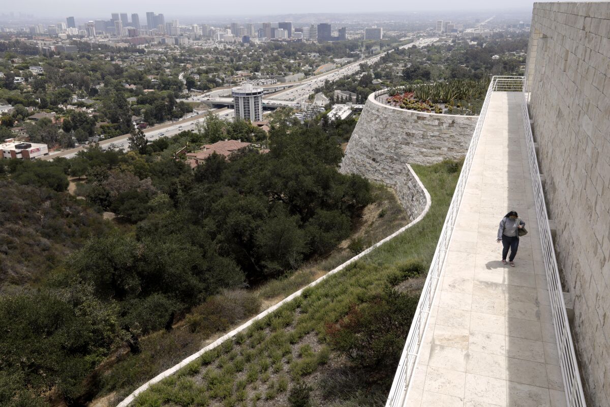 A visitor walks along an outdoor pathway at the Getty
