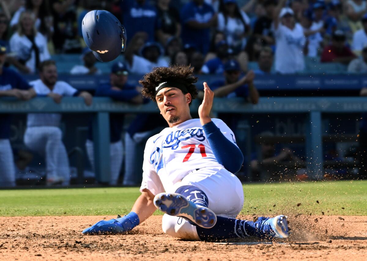 Dodgers baserunner Miguel Vargas slides to score a run against the Colorado Rockies on Oct. 4.