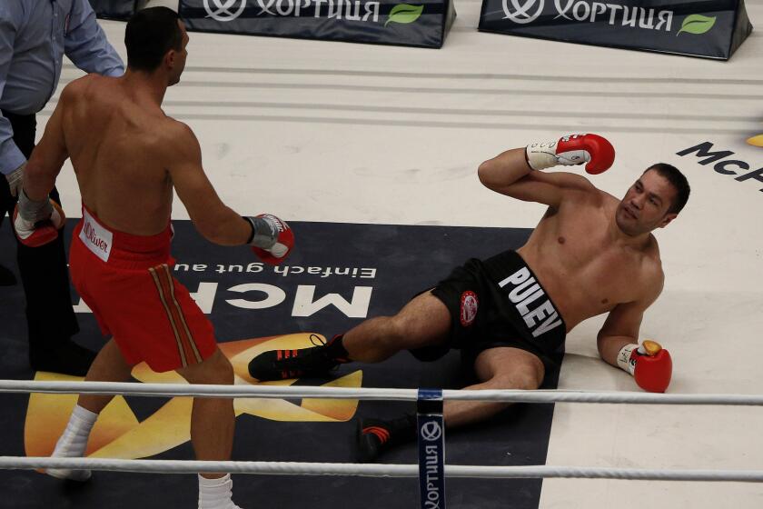 Wladimir Klitschko, left, knocks down Kubrat Pulev during their heavyweight title fight in Hamburg, Germany, on Saturday.