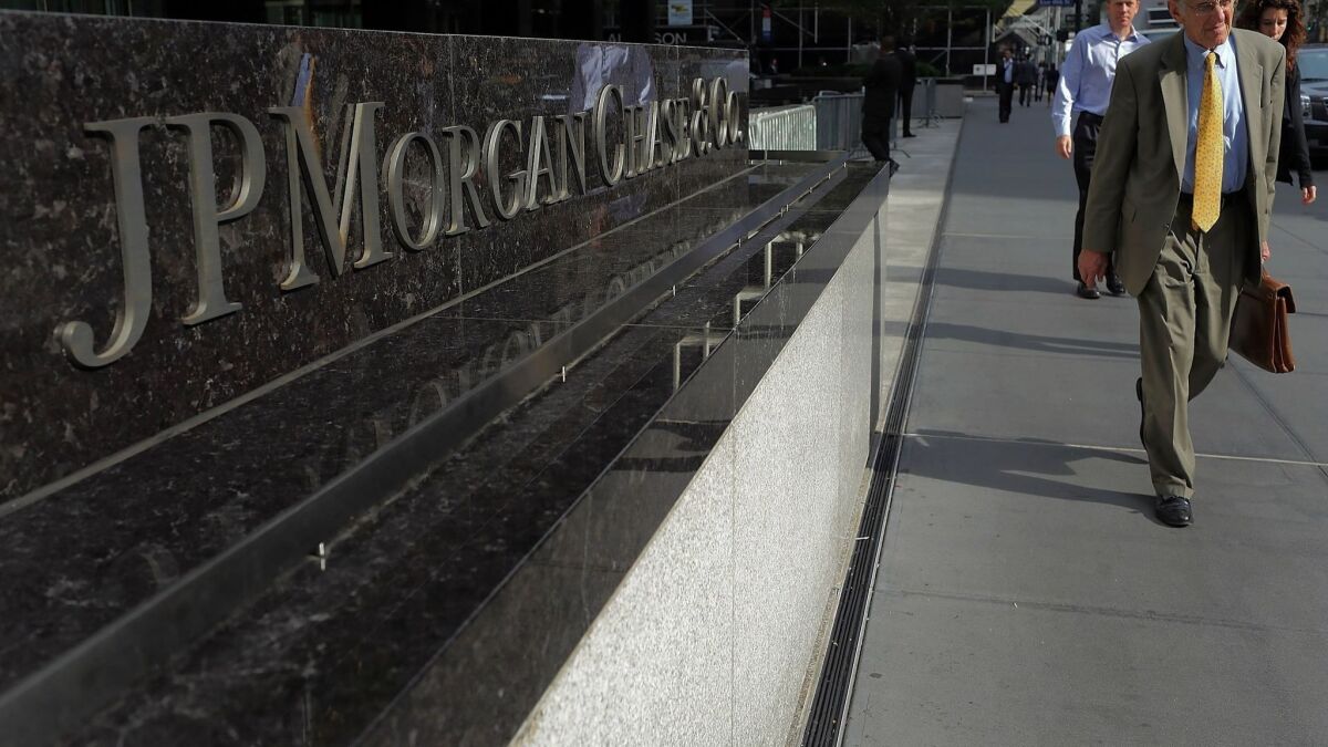 People pass a sign for JPMorgan Chase & Co. at its headquarters in Manhattan in this 2012 file photo.
