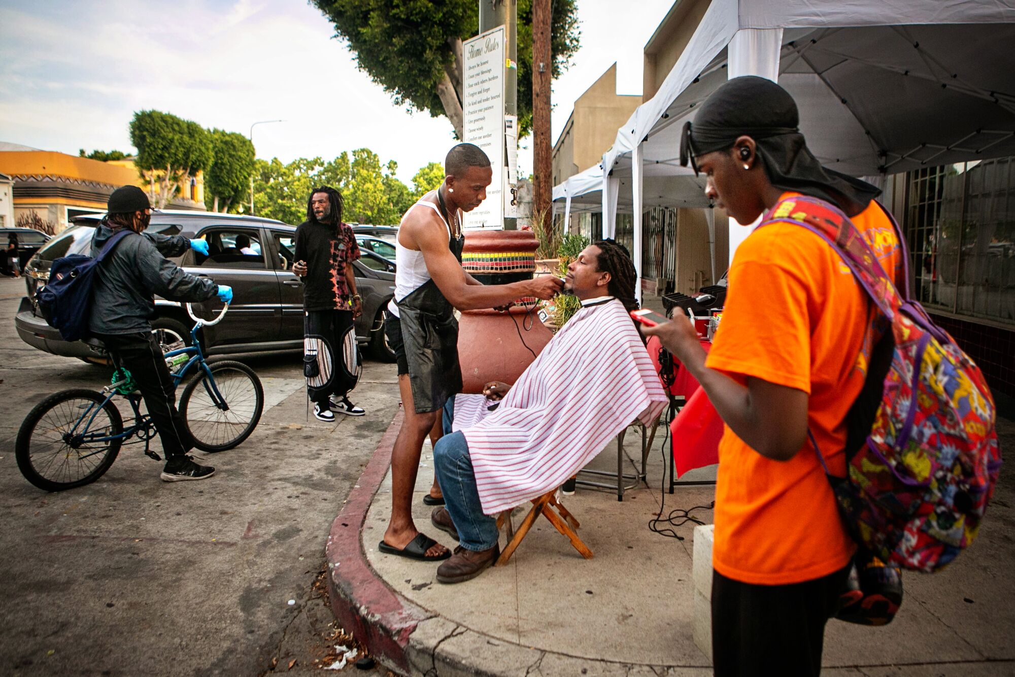 June 15: Jacket Rashad gives Rashad Karim a haircut on a street corner