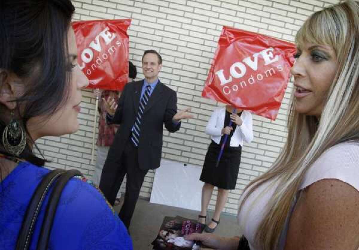 Former adult film industry performers Madelyne Hernandez, left, and Shelley Lubben talk to each other in March as Michael Weinstein, president of the AIDS Healthcare Foundation, addresses a small crowd about requiring porn actors to use condoms.