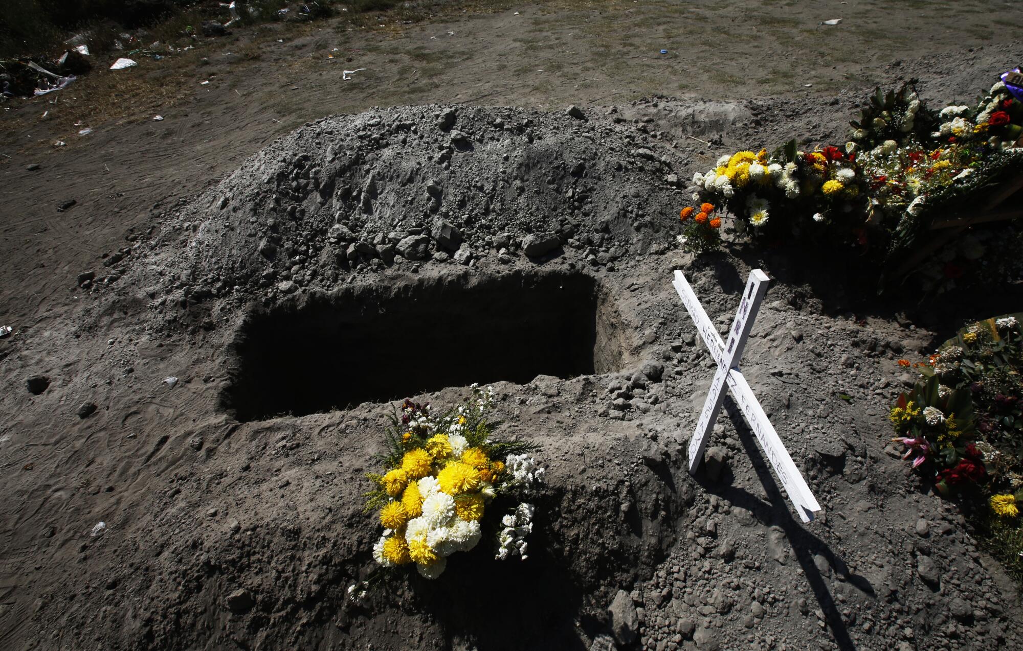 A hole dug in a dirt gravesite
