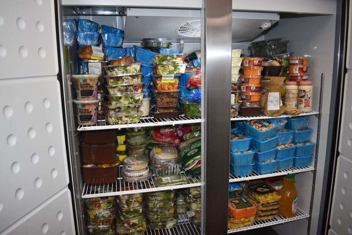 One of the refrigerators filled with donated food from local stores.