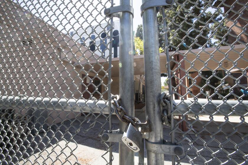 Los Angeles, Ca-July 13, 2020: A gate in front of Hamilton High School on Robertson Blvd in Los Angeles is locked on July 13, 2020. Supt. Austin Beutner announced today that all schools in LAUSD, including Hamilton High School will not re-open for classes on August 18, 2020, because of the coronavirus outbreak. The nation's second largest school system will continue with online learning until further notice. (Mel Melcon/Los Angeles Times)