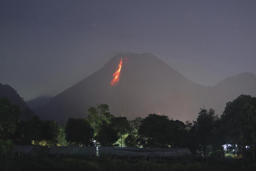 In this time-lapsed photo, hot lava runs down from Mount Merapi as its activity continues since local geological authority raised the alert level to the second-highest level in November, in Kaliurang, Indonesia, early Sunday, Jan. 24, 2021. Merapi is one of the most volatile among the country's more than 120 volcanoes. (AP Photo/Trisnadi)