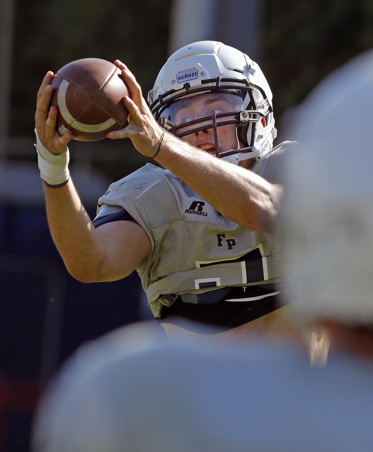 Flintridge Prep's Ben Grable gets control of a pass to him after bobbling it high into the air as he practices plays at pre-season football practice at Flintridge Prep on Monday, August 19, 2019.