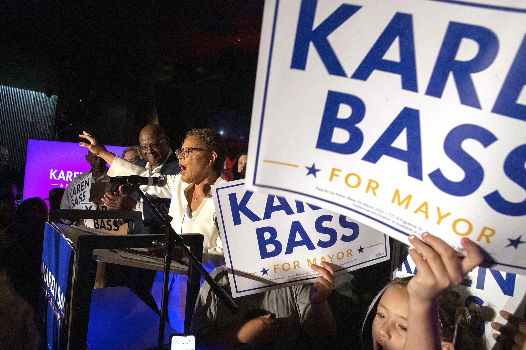 Karen Bass gesturing as she speaks at an election event, surrounded by supporters
