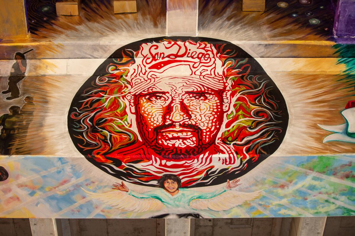 A mural presents the face of man wearing a San Diego baseball hat