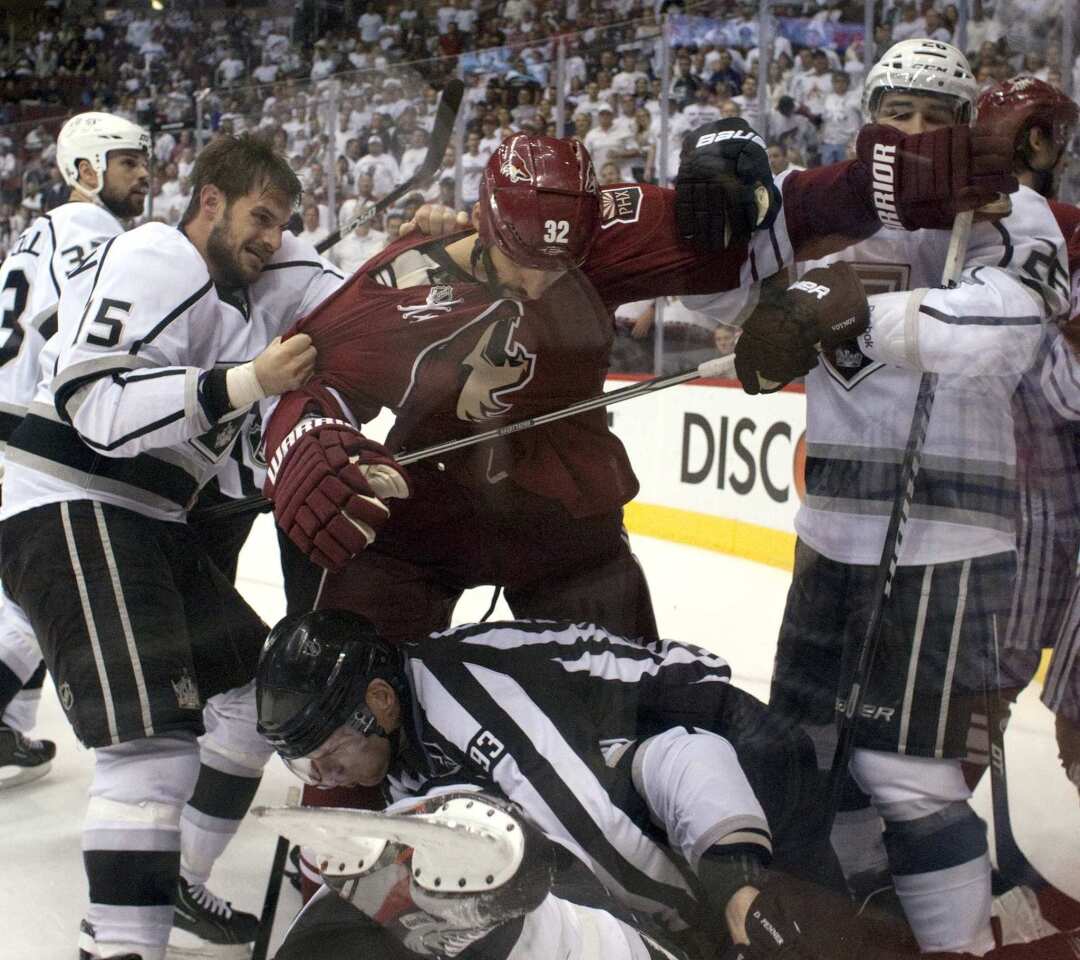 Kings forwards Brad Richardson and Jarret Stoll hold back Coyotes defenseman Michael Stone as a referee tries to break up a fight during Game 2 on Tuesday night at Jobing.com Arena.