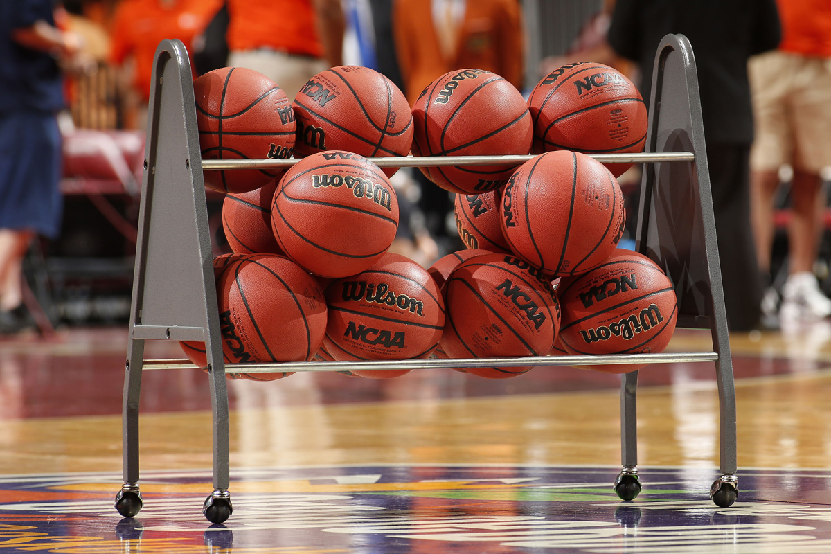 Basketballs in a rack on the court.