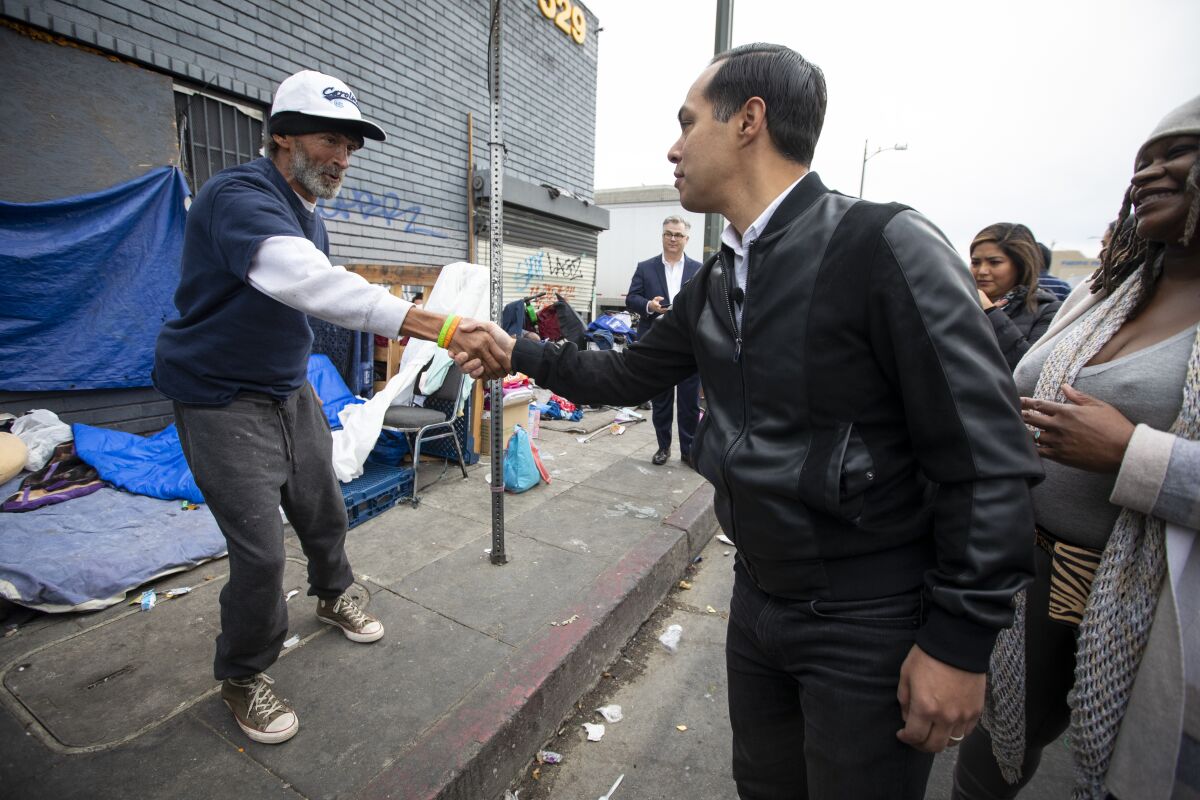 Chris Smith greets former U.S. Secretary of Housing and Urban Development Julián Castro on L.A.'s skid row.