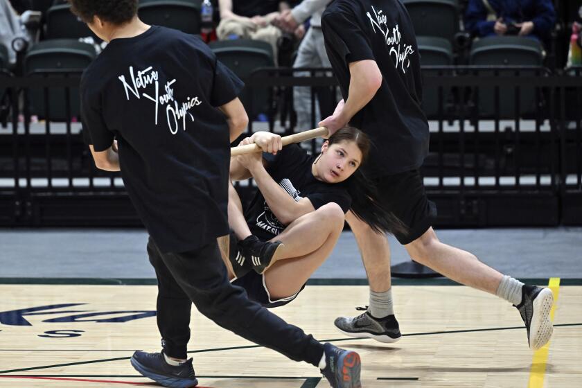 Eulalia Roman, 12, with team Mat-Su competes in the wrist carry on the first day of the Native Youth Olympics Senior Games at the Alaska Airlines Center, Thursday, April 25, 2024, in Anchorage, Alaska. (Bill Roth/Anchorage Daily News via AP)