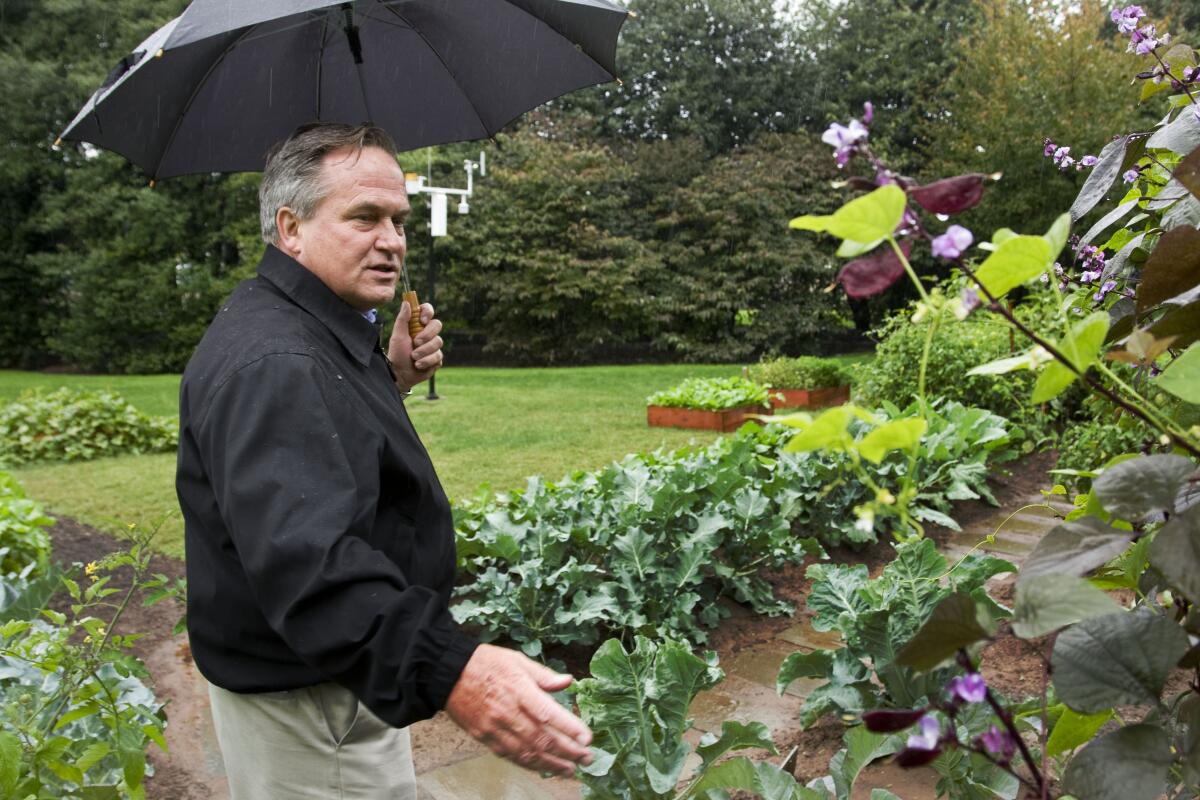 ARCHIVO - Dale Haney, principal jardinero de la Casa Blanca, habla con la primera dama Michelle Obama 