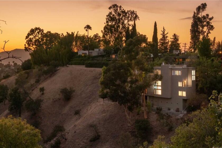 The three-story residence takes in city and canyon views from walls of glass and multiple decks.