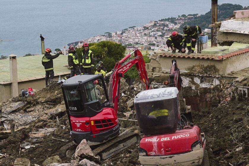 Search teams work on a landslide in Casamicciola, on the Italian resort island of Ischia, in southern Italy, Wednesday, Nov. 30, 2022, which killed eight people and left four missing where a big chunk of the Mount Epomeo detached destroying houses and pushing vehicles down into the sea. (AP Photo/Salvatore Laporta)