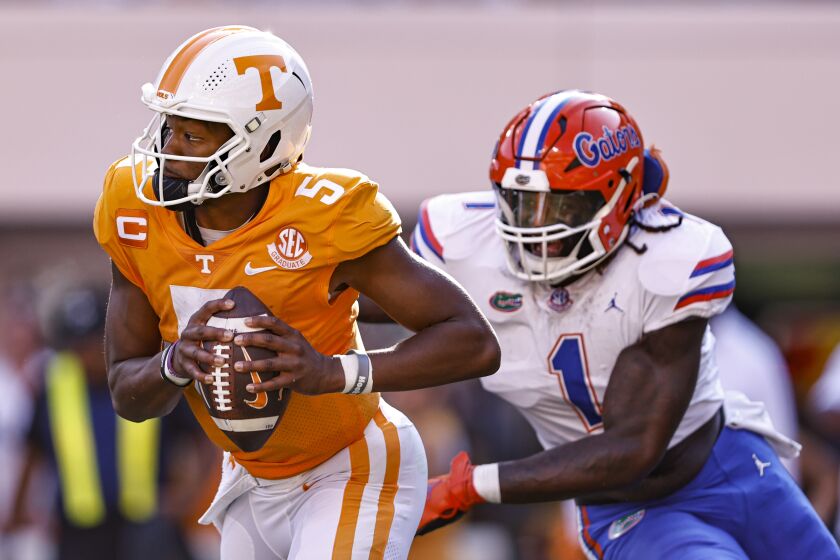 Tennessee quarterback Hendon Hooker (5) runs for yardage while pursued by Florida linebacker Brenton Cox Jr. (1) during the first half of an NCAA college football game Saturday, Sept. 24, 2022, in Knoxville, Tenn. (AP Photo/Wade Payne)