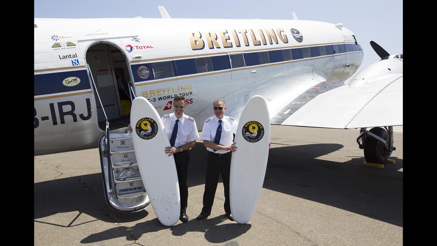 Pilots Paul Bazeley, left, and Francisco Agullo pose for a photo in front of a World War II-era Breitling DC-3 aircraft at John Wayne Airport on Friday, July 14. A crew of three is attempting to set the world record as the oldest plane to circle the globe.