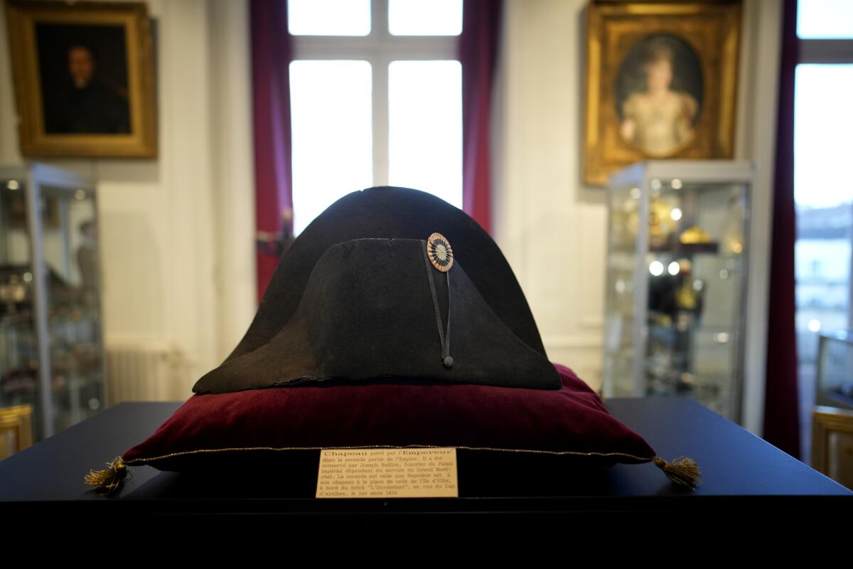 One of the signature broad, black hats that Napoléon wore when he ruled 19th century France sits on a velvet pillow. 
