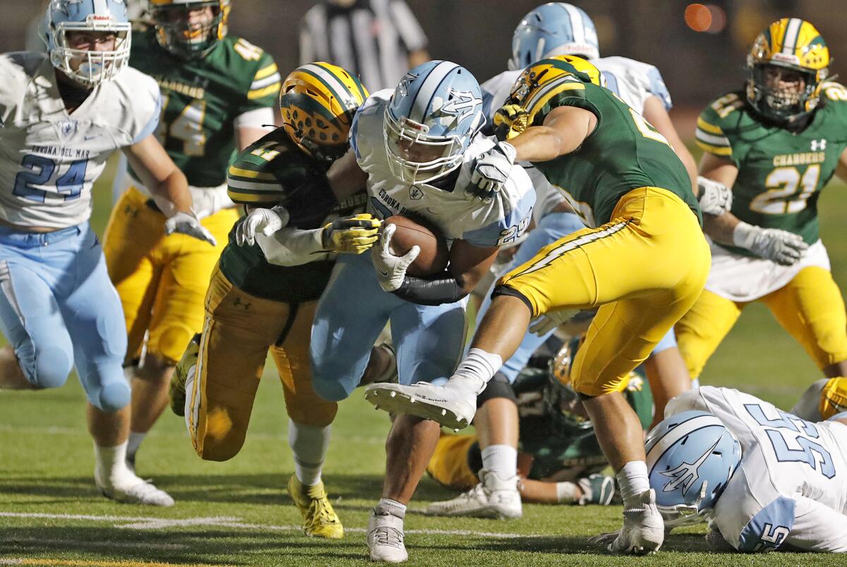 Corona Del Mar running back Evan Sanders (25) fights through tackles against Edison in football action.