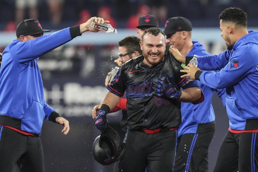 Alejandro Kirk, de los Azulejos de Toronto es felicitado por sus compañeros de equipo después de dejar tendidos a los Cardenales de San Luis con sencillo que remolcó una carrera duante la 11ma entradadel juego interligas, en Toronto, el viernes 13 de septiembre de 13 de 2024. (Chris Young/The Canadian Press via AP)