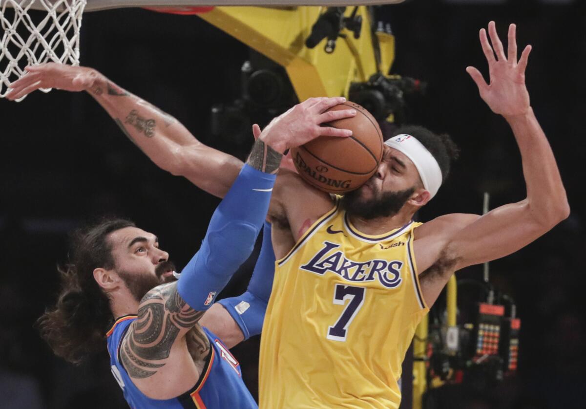 Lakers center JaVale McGee (7) takes the ball off his face while battling Oklahoma City Thunder center Steven Adams (12) for a first half rebound at Staples Center on Tuesday.