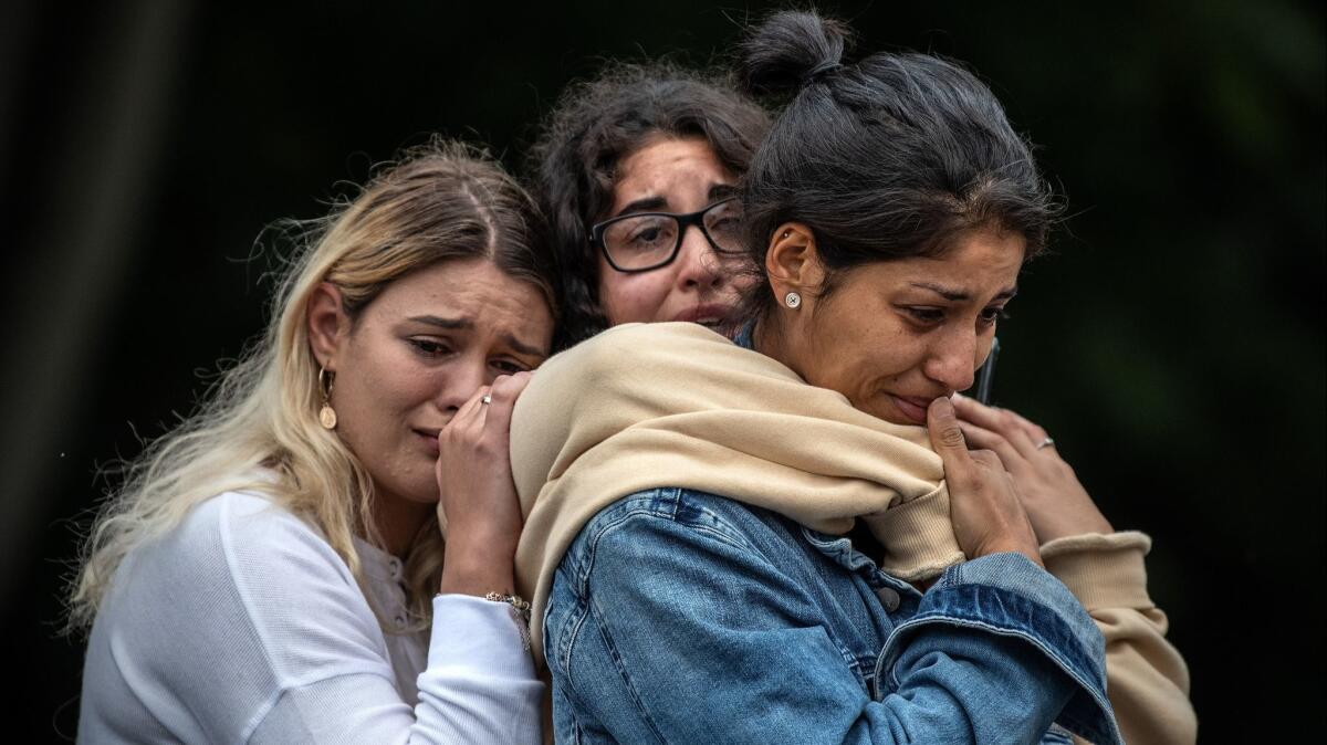 Women weep together near Al Noor mosque in Christchurch, New Zealand, on Monday. A terrorist attack on two mosques last week killed at least 50 people.