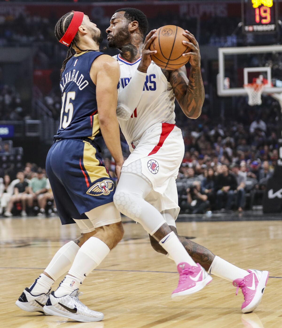 Clippers guard John Wall collides with Pelicans guard Jose Alvarado on a drive to the basket.