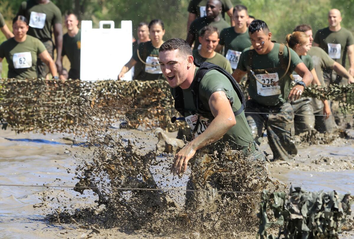 Participants slog through a mud pit as they compete in the annual Marine Corps Mud Run. | (Eduardo Contreras / San Diego Union-Tribune)
