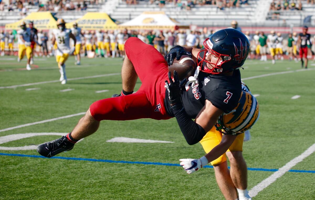 Palos Verdes receiver Luke Layton catches the ball in midair as he gets hit by Edison cornerback Jared Schnoor.