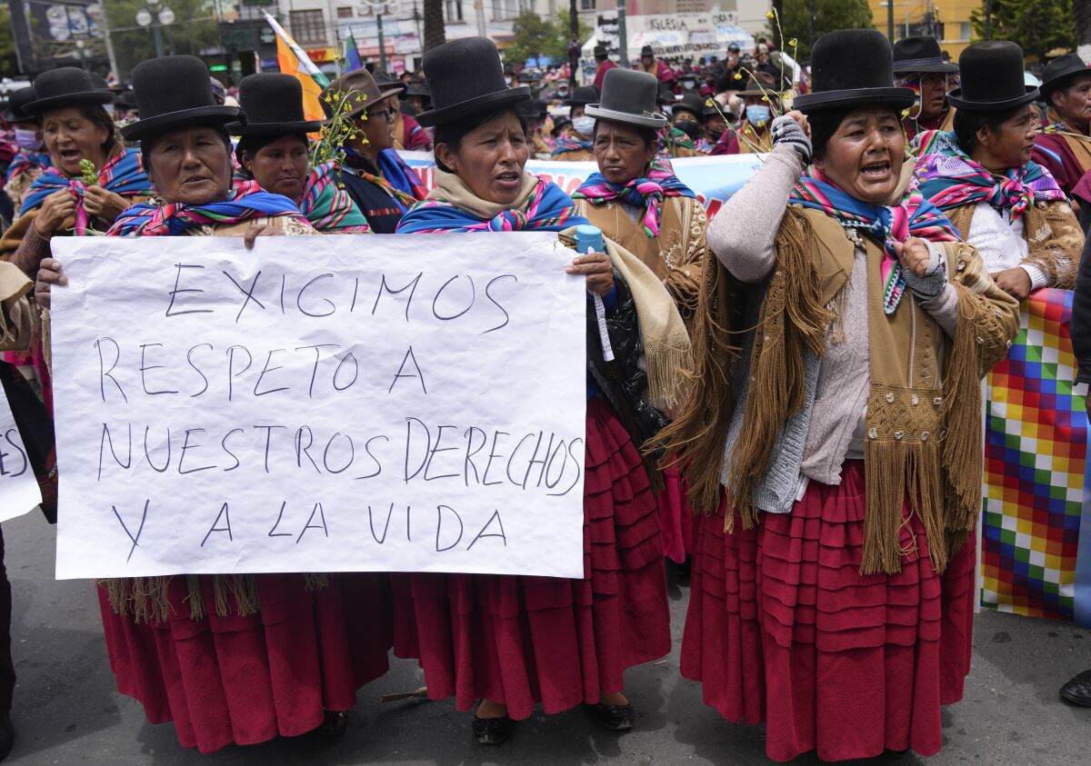 Aymara Indigenous women hold a sign that reads in Spanish "We demand respect for our rights and life," during a protest against a government decree requiring proof of vaccination amid the COVID-19 pandemic in La Paz, Bolivia, Tuesday, Jan. 11, 2022. The measure, which goes into effect on Jan. 26, will affect people's ability to enter establishments and use public transportation. (AP Photo/Juan Karita)