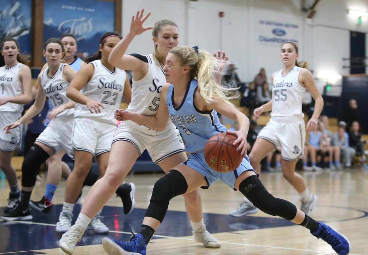 Corona del Mar's Haley Esquino drives to the basket against Newport Harbor's Genevieve Perry in the Battle of the Bay game on Thursday.