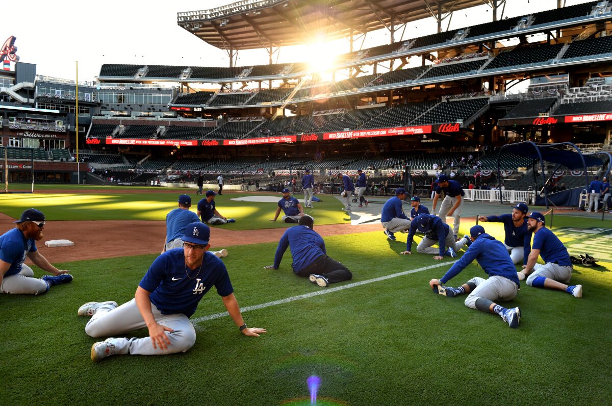 Dodgers players warm up before Game 1 of the NLCS against the Atlanta Braves at Truist Park on Saturday.