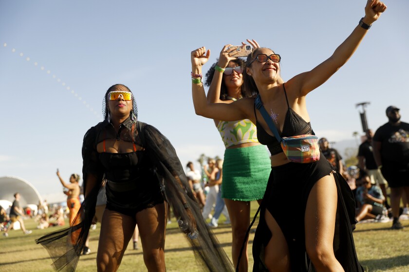 Coachella fans Dani Flateau, from left, Brittiany Bernard and Erinn Fontno dance as Ari Lennox performs on Day 1